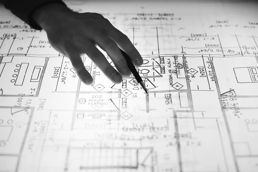 Hand pointing at an architectural floor plan