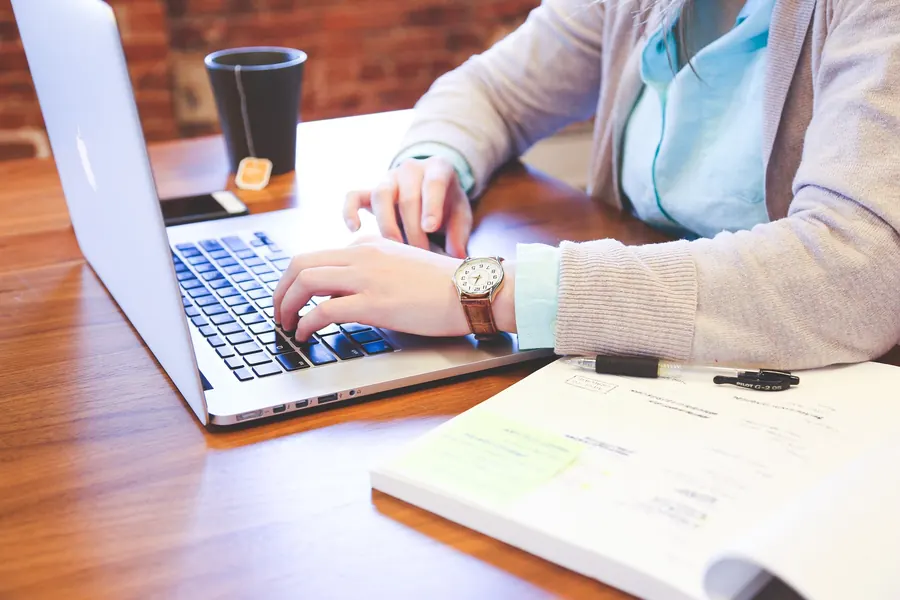 Translator working on a laptop with printed notes